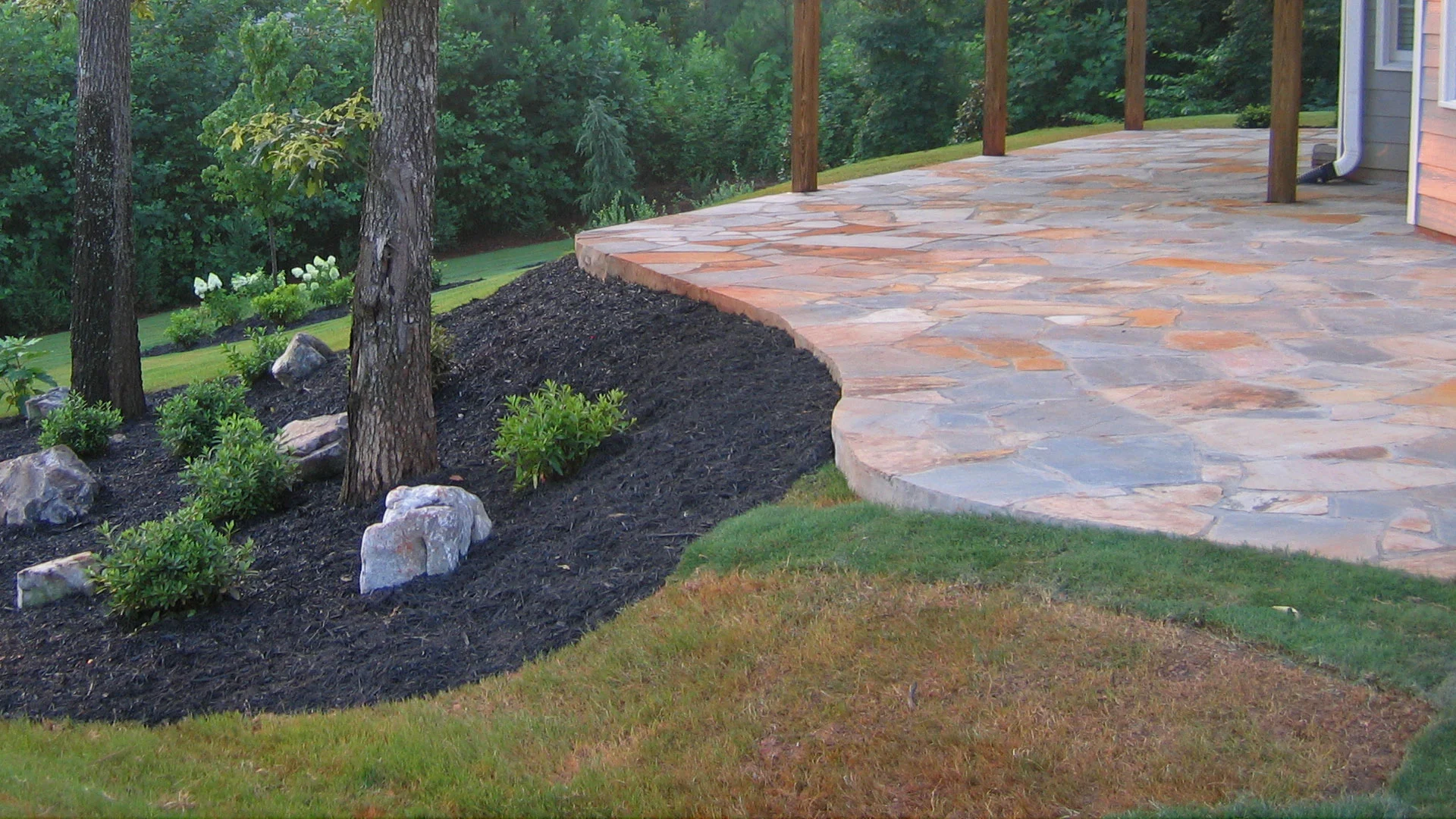 Flagstone patio constructed in the backyard of a home in Smyrna with softscaping.