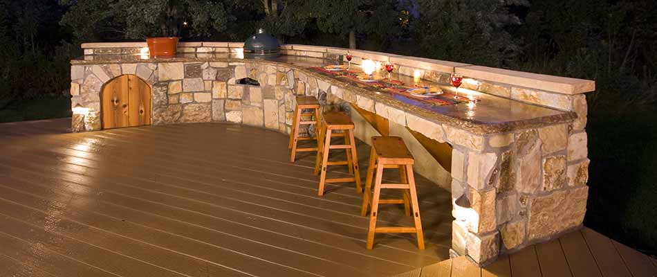 Custom stone outdoor kitchen bar with stools near Atlanta, GA.