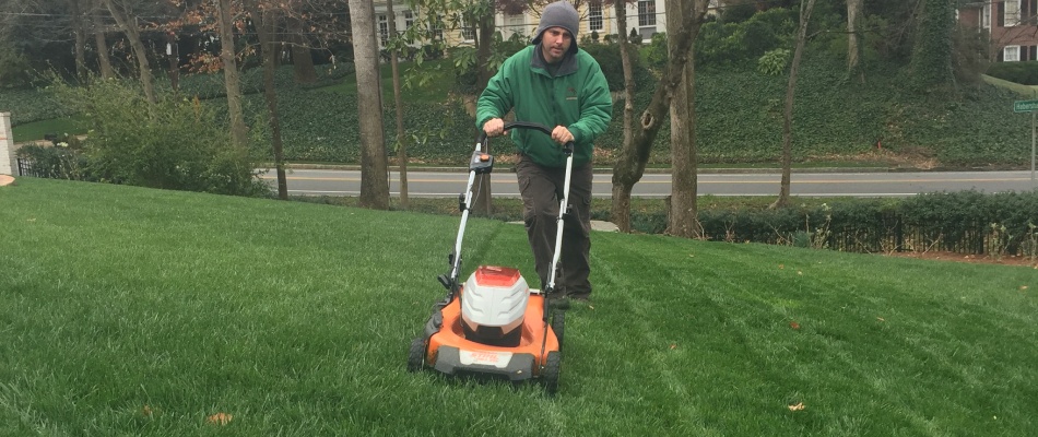 Worker mowing lawn in Milton, GA.