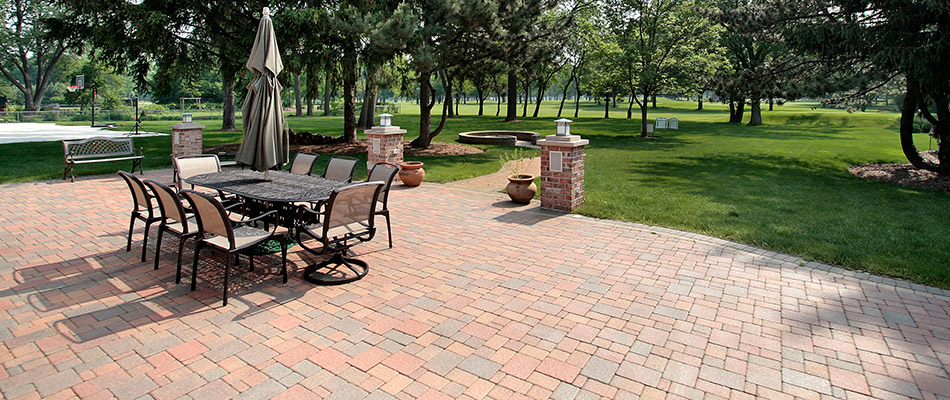A red and grey paver patio with a dining set on a property in Brookhaven, GA.