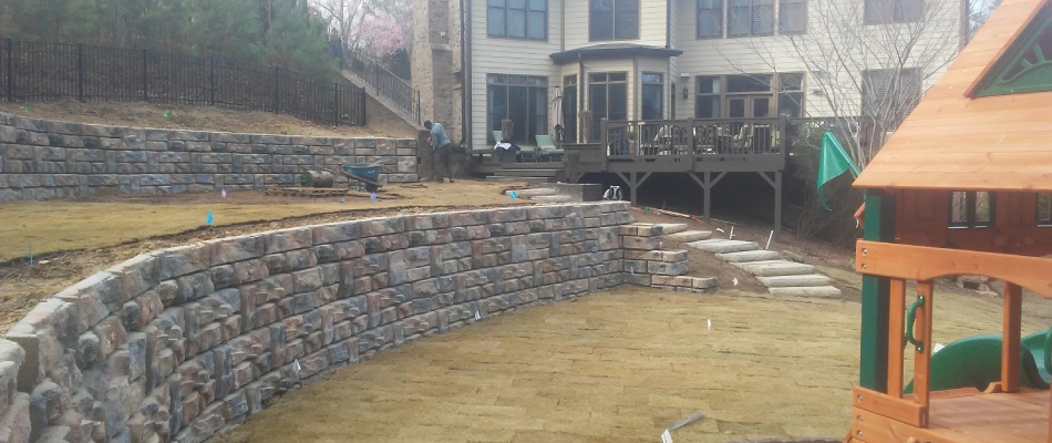Retaining wall installed beside ongoing sod installation in Roswell, GA.