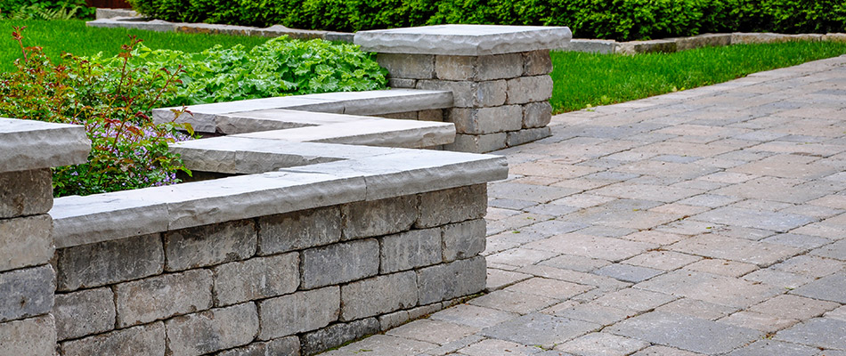 An elegant seating wall made with concrete pavers in a garden.