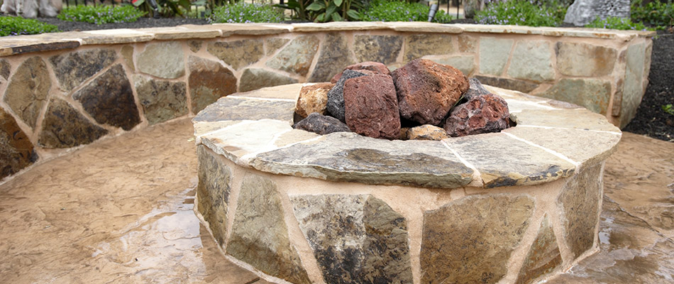 A custom fire pit with seating wall installed on a property in Marietta, GA.