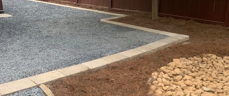 Straw mulch added around gravel patio edged with pavers in Atlanta, GA.